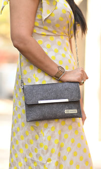 A woman is holding Zenkindstore's Envelope Sling Bag